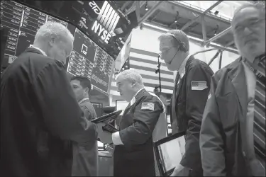  ?? Bloomberg News/MICHAEL NAGLE ?? Traders work Monday at the post where Equifax Inc. shares are traded on the floor of the New York Stock Exchange.