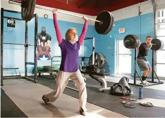  ?? Joey Ivansco / Associated Press ?? Kulsoom Abdullah, left, trains at Crossfit gym in Atlanta, Ga. In 2011, she became the first woman to wear a hijab in an internatio­nal weightlift­ing competitio­n.