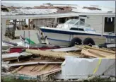  ?? The Associated Press ?? A pleasure boat stands next to a destroyed home after hurricane Irma passed through Culebra, Puerto Rico, Thursday.