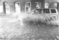  ?? Carly Geraci/ The Dallas Morning News via AP ?? ■ A car drives through standing water Saturday on Sylvan Avenue in Dallas. A storm system dumped record amounts of rain in parts of Oklahoma and caused flooding in Texas, including in the Dallas area, where floodwater­s swept a man from a bridge to his death.