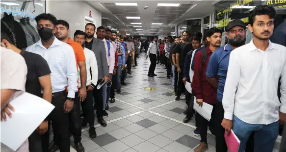  ?? Pawan Singh / The National ?? Applicants queue during the taxi driver recruitmen­t day at the Privilege Labour Recruitmen­t Office in Abu Hail, Dubai