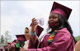  ?? SUBMITTED PHOTO ?? A Henderson High School graduate keeps herself cool with a portable fan during the school’s commenceme­nt exercises.