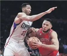  ?? Sean M. Haffey Getty Images ?? WESLEY JOHNSON, whom the Clippers re-signed before this season, looms over Houston’s Eric Gordon earlier this month.