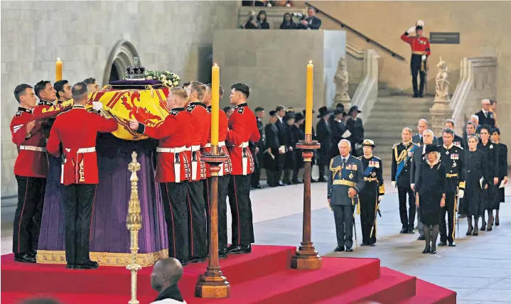  ?? ?? Members of the Royal family watch as Queen Elizabeth II’S coffin is placed in Westminste­r Hall to lie in state – a spectacle that has drawn hundreds of thousands of mourners to the capital, below