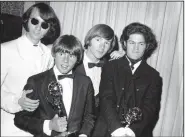  ?? (AP file photo) ?? Michael Nesmith (left photo, from left), Davy Jones, Peter Tork and Micky Dolenz of The Monkees pose with their Emmy award for best comedy series in June 1967 in Los Angeles. At right, Nesmith rehearses for a show in Escondido, Calif., in 2012. Nesmith and Dolenz performed a final show in November as they wrapped up “The Monkees Farewell Tour” at the Greek Theatre in Los Angeles.