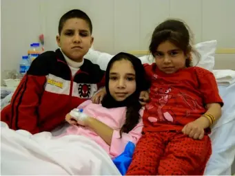  ??  ?? Amina (centre) with her brother and sister after the operation (Simona Sikimic/Save the Children)