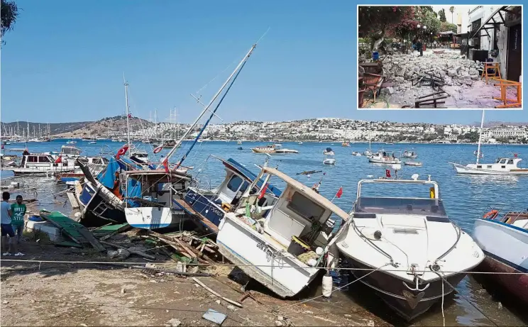  ?? — Reuters ?? People surveying damaged boats after an earthquake and a tsunami hit the resort town of Gumbet in Turkey. Two people were killed and 200 were injured on the Greek holiday island of Kos (inset) by the strong earthquake.