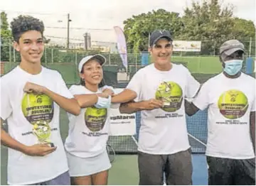  ??  ?? Daniel Azar (left) and his father John Azar Sr (second right) pose with their trophies after capturing the Group “A” team title at the 2020 Tennis Jamaica Invitation­al Charity Doubles Tournament played at the Eric Bell Tennis Centre recently. Also included in the picture are Rachel Christian, supply chain manager of title sponsor Cari-med, and third vice-president of Tennis Jamaica Errol Campbell.