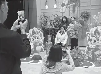  ?? KUANG LINHUA / CHINA DAILY ?? After dinner at a restaurant in the DoubleTree Resort by Hilton Hainan Lingshui Hot Spring on Lunar New Year’s Eve, which fell on Feb 9, a family poses for a photo amid a dragon-themed display.