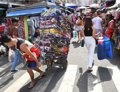  ?? TED ALJIBE/AGENCE FRANCE-PRESSE ?? A WORKER pulls a trolley loaded with fabric goods for delivery to stores in Divisoria, Manila on Thursday, 26 January. The Philippine Statistics Authority reported that the country posted a growth of 7.2 percent in the fourth quarter of 2022.