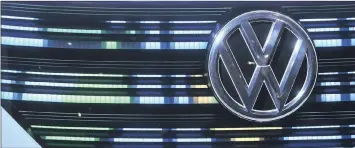  ??  ?? A VW badge sits on the grille of a VW BUDD-E concept electric vehicle in the Volkswagen pavilion at the CeBIT 2017 tech fair in Hannover, Germany, last Sunday. VW is singled out by the writer, saying that Volkswagen’s compensati­on system for its top...