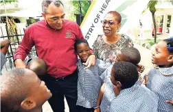  ?? RICARDO MAKYN/MULTIMEDIA PHOTO EDITOR ?? Minister of Health Dr Christophe­r Tufton and Dr Erica Gordon Veitch, paediatric dentist, interact with students from Seaward Primary and Junior High School at the press launch of Phase Three of the obesity prevention campaign held at the Terra Nova All Suite Hotel on Thursday, October 11.