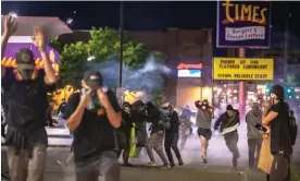  ?? Photograph: Paul Winner/Rex/Shuttersto­ck ?? A crowd of Black Lives Matter protesters runs from pepper ball shots from riot police in Denver in May 2020.