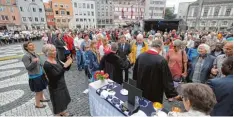  ?? Foto: Michael Hochgemuth ?? Abendmahl beim Open Air Gottesdien­st am Augsburger Rathauspla­tz: Dafür waren eigens Altäre aufgebaut worden.