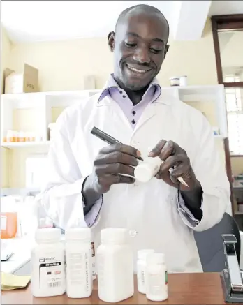  ??  ?? TARGETED: Pharmacist Michael Otieno dispenses antiretrov­iral drugs at the Mater Hospital in Nairobi, Kenya.