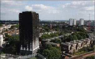  ?? The Associated Press ?? GRENFELL TOWER: The remains of Grenfell Tower stand Saturday in London. Police Commander Stuart Cundy said Saturday it will take weeks or longer to recover and identify all the dead in the public housing block that was devastated by a fire early...