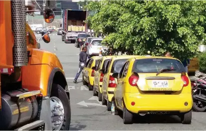  ??  ?? En la calle 30 con carrera 43, al frente y al lado de la nueva sede de EPS Sura, los taxis se agrupan ocupando parte de la vía. Los vecinos se quejan de la movilidad en las calles.