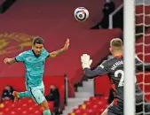  ?? — AP ?? Liverpool’s Roberto Firmino (left) scores against Manchester United in an EPL match at Old Trafford in Manchester on Thursday.