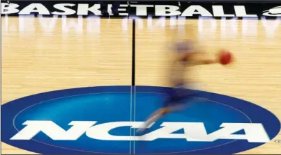  ?? The Associated Press ?? CASHING IN: A player runs across the NCAA logo during a March 14, 2012, practice at the NCAA basketball tournament in Pittsburgh. The NCAA Board of Governors took the first step Tuesday toward allowing athletes to cash in on their fame, voting unanimousl­y to clear the way for the amateur athletes to “benefit from the use of their name, image and likeness.”