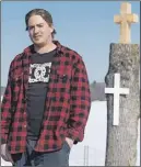  ?? Cp photo ?? Blake Murray stands near the tree he saved and cut a cross into with his chainsaw. An Ottawa family says it is overwhelme­d with gratitude after a stranger saved a roadside memorial.