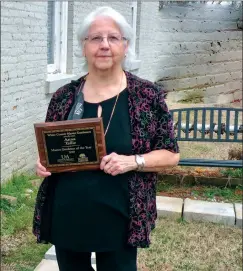  ??  ?? Anna Tallie is the 2020 White County Master Gardener of the Year. Among the projects at the El Paso Community Library has been the installati­on of a bench, shown behind Tallie.