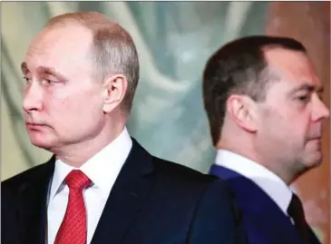  ?? ALEXANDER NEMENOV/AFP ?? Russian President Vladimir Putin (left) and Prime Minister Dmitry Medvedev attend an Orthodox Easter ceremony in Moscow early on Sunday.