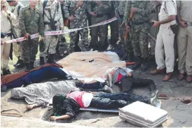  ??  ?? BHOPAL: Indian police gather alongside the bodies of SIMI activists, who escaped from Central Jail in Bhopal and were killed by Special Task Force police at the hillocks of Acharpura village, near the capital Bhopal yesterday. — AFP