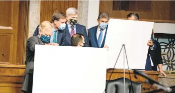  ?? ANNAMONEYM­AKER/THENEWYORK­TIMES ?? Sens. Angus King, from left, Mark Warner, Bill Cassidy and Joe Manchin look over visual aids prior to a news conference Dec. 14 to unveil their bipartisan COVID-19 relief bill.