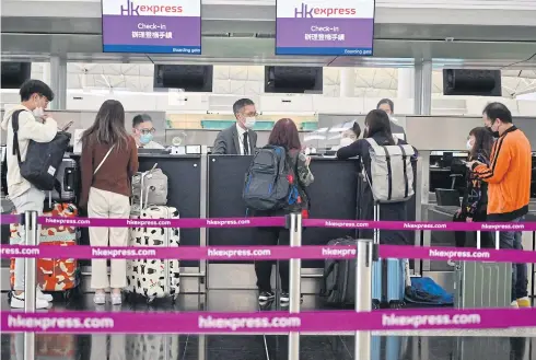  ?? AFP ?? Passengers check-in at the internatio­nal airport in Hong Kong.