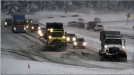  ?? TED S. WARREN — THE ASSOCIATED PRESS ?? Washington Dept. of Transporta­tion snow plows work on a stretch of eastbound Interstate Highway 90, Thursday, as snow falls near Snoqualmie Pass in Washington state.