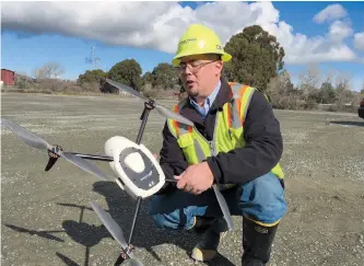  ??  ?? Mike Moy, an assistant plant manager for Lehigh Hanson Cement Group, inspects a Kespry drone he uses to survey inventorie­s of rock, sand and other building materials at a mining plant in Sunol, California. — IC