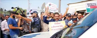  ??  ?? A Hamas security officer tries to prevent demonstrat­ors from blocking vehicles carrying UN Secretary-General Antonio Guterres upon his arrival at the Palestinia­n side of the Erez border crossing in Beit Hanoun, northern Gaza Strip, on Wednesday. (AP)