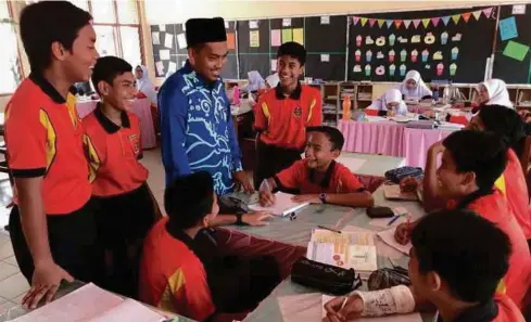 ??  ?? Mohd Syarafuddi­n beramah mesra bersama-sama pelajar di dalam kelas.
