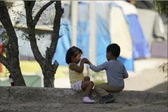  ?? Eric Gay/Associated Press ?? Children play at a camp of asylum-seekers in Matamoros, Mexico, recently. Facilities that hold migrants are nearing capacity, which has been reduced because of COVID-19.