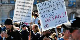  ??  ?? A Bordelais protester holds a placard reading “The army ... To protect us from the police??! Macron get out!” in Bordeaux.