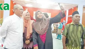  ??  ?? PENGUNJUNG mengambil peluang berswafoto bersama Ronald pada majlis rumah terbuka Hari Raya Aidilfitri anjuran Pejabat Parlimen Beluran.