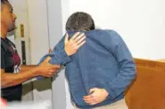  ?? THE ASSOCIATED PRESS ?? A 19-year-old dual U.S.-Israeli citizen covers his face as he is brought to court Thursday in Rishon Lezion, Israel. Israeli police said the man, who was not indentifed, is the prime suspect behind a wave of bomb threats against Jewish community...