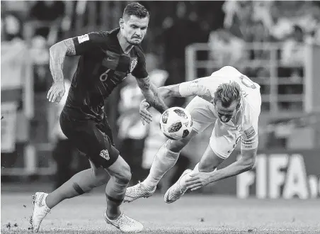  ?? Alastair Grant / Associated Press ?? England’s Harry Kane, right, gets the worst of a challenge with Croatia’s Dejan Lovren during Wednesday’s semifinal in Moscow.