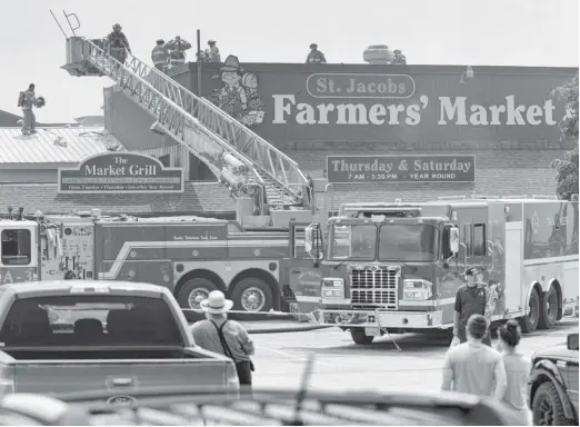  ?? [WHITNEY NEILSON / THE OBSERVER] ?? An all-too-familiar scene, fire crews from St. Jacobs, Elmira, Conestogo, and Breslau were called to a fire at the St. Jacobs Farmers’ Market May 26, this time to the roof of the Peddlar’s Village building.