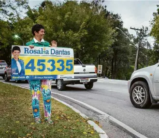  ?? Eduardo Anizelli/Folhapress ?? Candidatos Aliceo Cavalieri e Rosália Dantas, do PSDB, seguram cartazes de suas campanhas na av. Yojiro Takaoka, em Santana de Parnaíba, uma das cidades do condomínio Alphaville