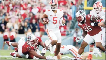  ?? Karl B DeBlaker / Associated Press ?? Clemson’s D.J. Uiagalelei (5) runs away from North Carolina State’s Davin Vann (45) during the second half on Saturday in Raleigh, N.C.