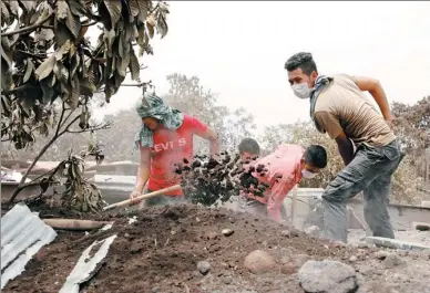  ?? CARLOS JASSO / REUTERS ?? Residents shovel ashes while looking for remains at an area affected by the Fuego volcano’s recent eruption in San Miguel Los Lotes, Escuintla, Guatemala, on Thursday.