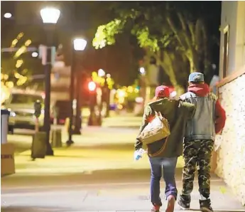  ?? U-T ?? A homeless couple walks in downtown San Diego after talking with volunteers for an annual homeless count in this 2016 photo. City leaders have made protecting the homeless a priority during the pandemic.