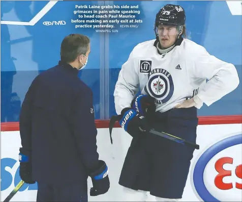  ?? KEVIN KING/ WINNIPEG SUN ?? Patrik Laine grabs his side and grimaces in pain while speaking to head coach Paul Maurice before making an early exit at Jets practice yesterday.