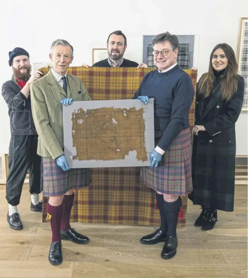  ?? ?? Peter Macdonald, Head of Research & Collection­s, The Scottish Tartans Authority (left) and John Mcleish, Chair, The Scottish Tartans Authority holding a piece of the original Glen Affric Tartan in front of the newly recreated tartan