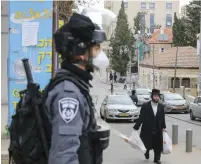  ?? (Marc Israel Sellem/The Jerusalem Post) ?? AN ULTRA-ORTHODOX man walks in the direction of a police officer yesterday.