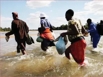  ?? ?? Zimbabwean­s crossing the Limpopo River into South Africa