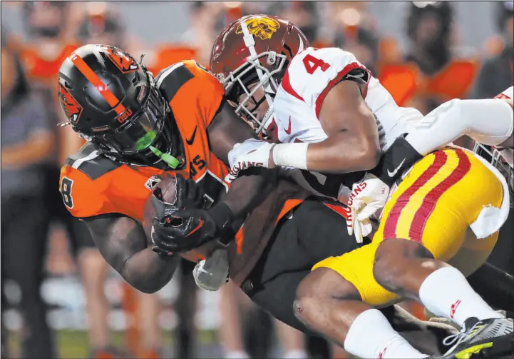  ?? Amanda Loman
The Associated Press ?? Oregon State running back Jam Griffin is brought down by Southern California defensive back Max Williams in the first half of a Pac-12 matchup of two unbeaten teams Saturday in Corvallis, Ore. The seventh-ranked Trojans (4-0), with two fourth-quarter touchdowns, including one inside two minutes, won 17-14, but failed to cover as 5½-point favorites.