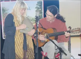  ?? MIKE ECKELS WESTSIDE EAGLE OBSERVER ?? Donna Mulhollan (left) plays a mountain dulcimer while husband Kelly Mulhollan accompanie­s on the guitar during the “Still on the Hill — Cane Hill” concert at Decatur Middle School gym. The pair was in Decatur on a mission to teach Arkansas students the history of Cane Hill.