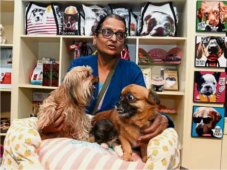  ?? — AFP ?? In the lap of luxury: Customer Veena Patel holding her beloved dogs as she speaks with a reporter at Critterati in Gurgaon.